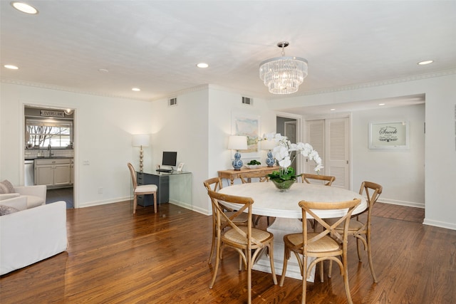 dining space with crown molding, dark wood-type flooring, sink, and a notable chandelier