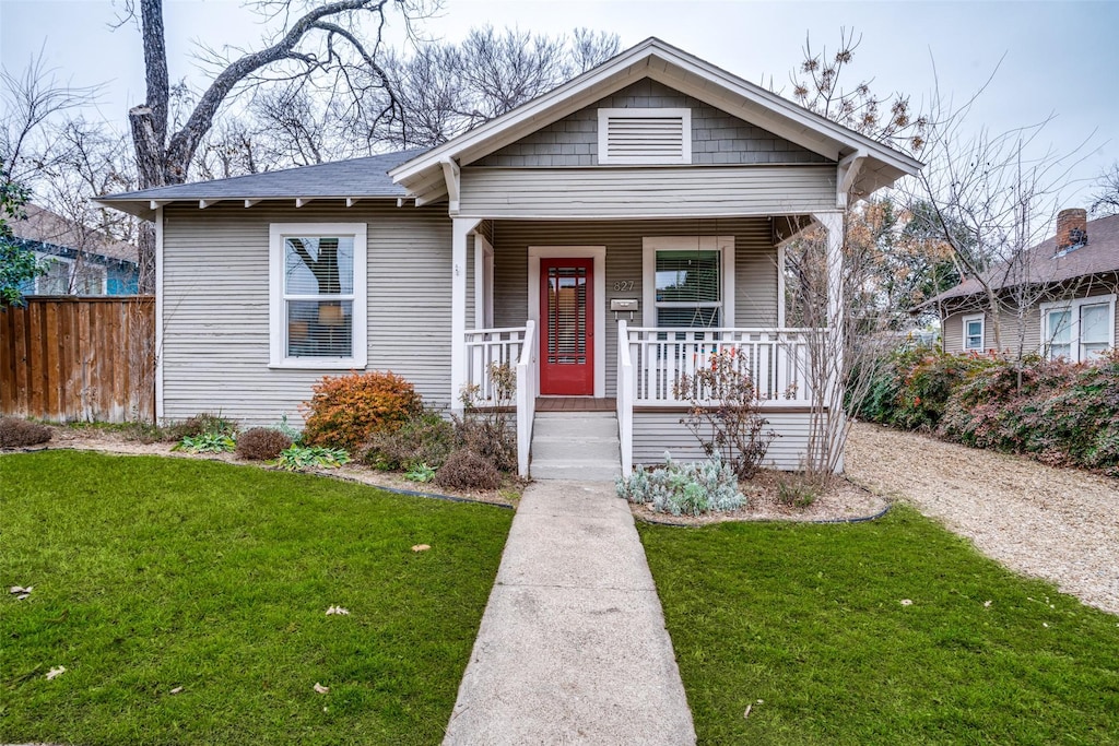 bungalow-style home featuring a front yard and covered porch