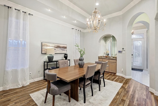 dining space with crown molding, a chandelier, and dark hardwood / wood-style flooring