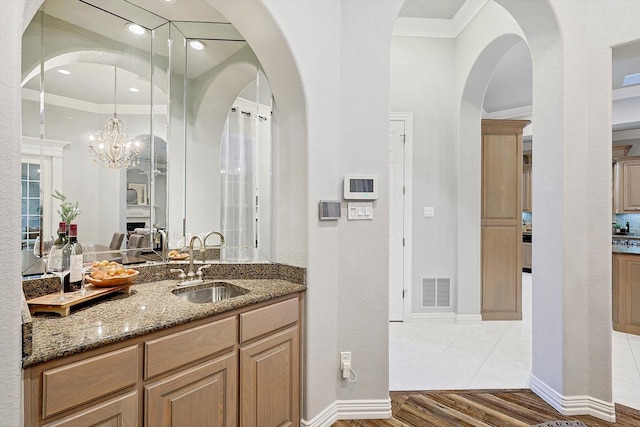 bathroom with vanity, wood-type flooring, and ornamental molding