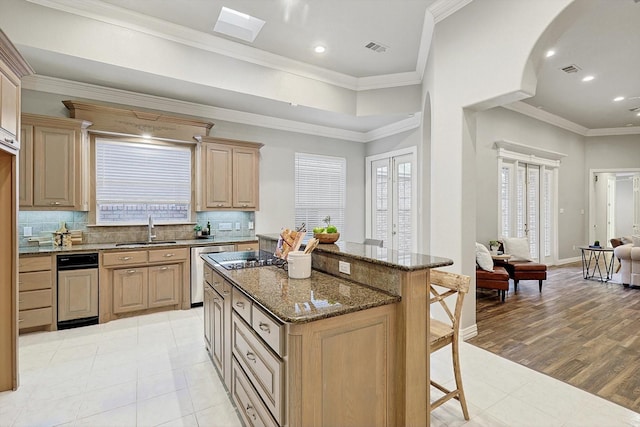 kitchen with sink, a center island, dishwasher, and light brown cabinets