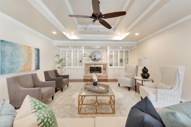 living room featuring a tray ceiling, ornamental molding, and built in features