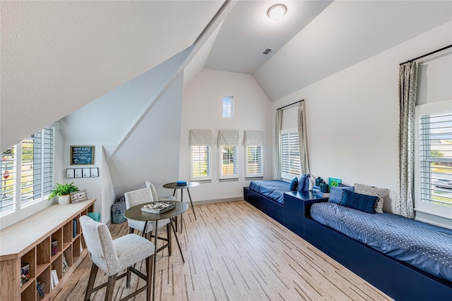 sitting room featuring hardwood / wood-style flooring, vaulted ceiling, and a wealth of natural light