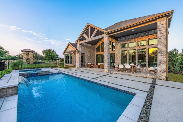 view of swimming pool featuring an in ground hot tub, pool water feature, and a patio