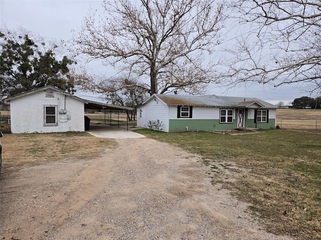 ranch-style home featuring a carport and a front yard