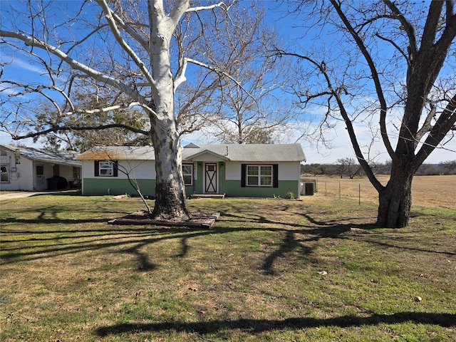 ranch-style home with cooling unit and a front lawn