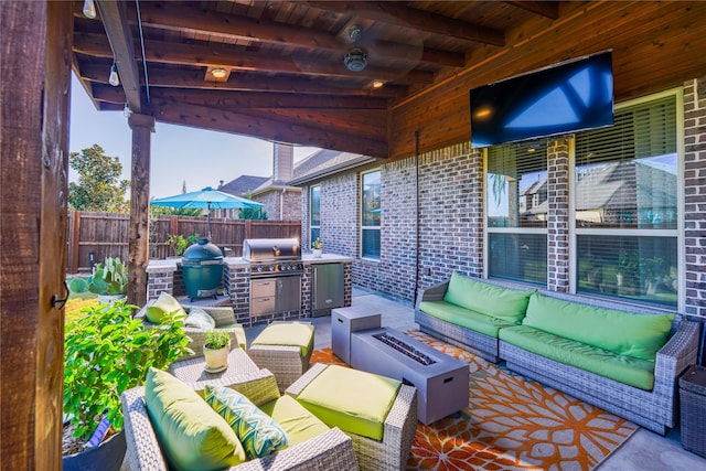 view of patio with an outdoor kitchen, a grill, and an outdoor living space with a fire pit