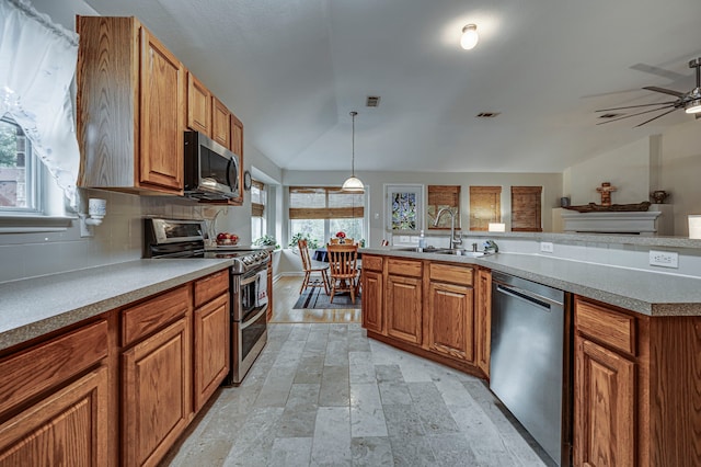 kitchen with lofted ceiling, sink, decorative light fixtures, appliances with stainless steel finishes, and decorative backsplash