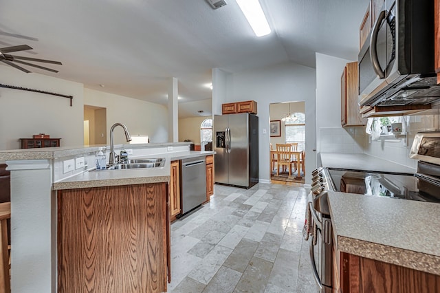 kitchen featuring lofted ceiling, sink, appliances with stainless steel finishes, an island with sink, and ceiling fan