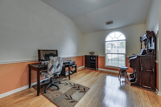 office with lofted ceiling and light hardwood / wood-style flooring