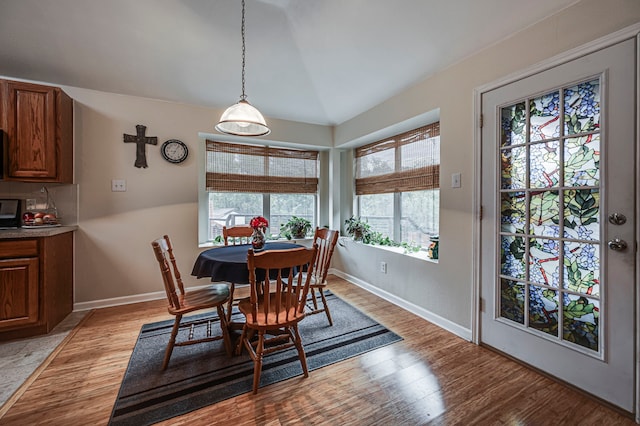 dining space featuring lofted ceiling and light wood-type flooring