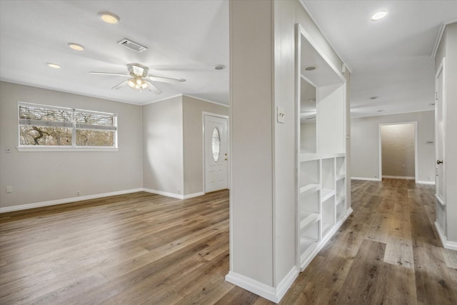 corridor with hardwood / wood-style flooring and ornamental molding