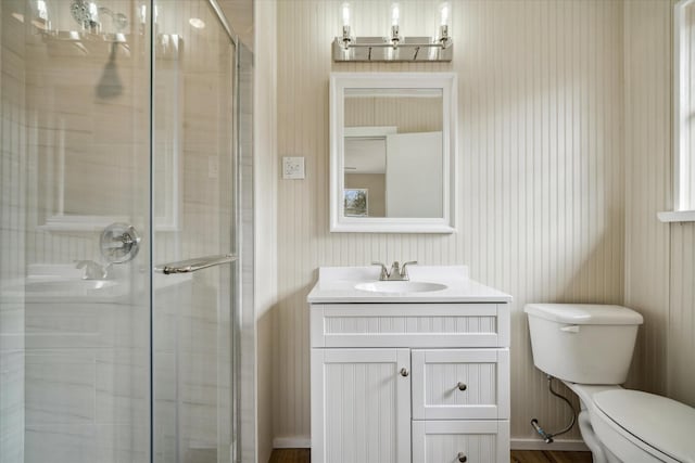 bathroom featuring vanity, toilet, and a shower with shower door