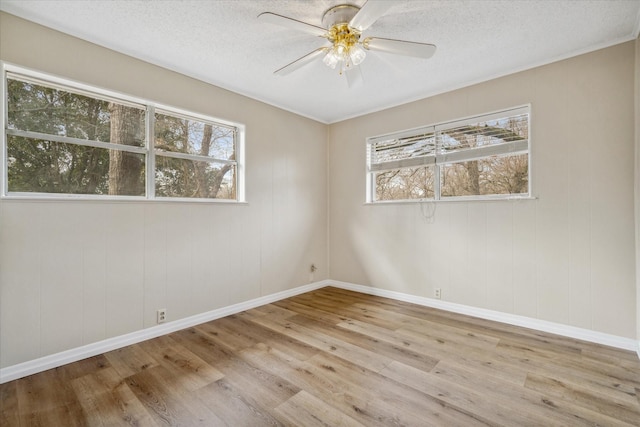 spare room featuring ceiling fan, light hardwood / wood-style flooring, and a textured ceiling