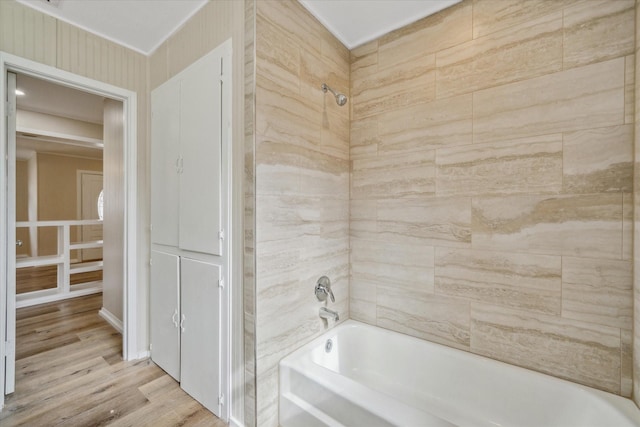 bathroom with hardwood / wood-style flooring and bathtub / shower combination