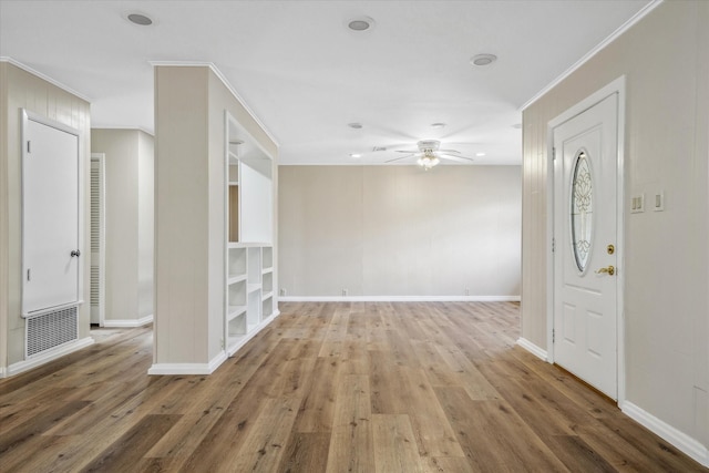 spare room featuring ceiling fan, ornamental molding, hardwood / wood-style floors, and built in features