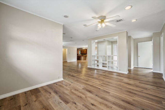 empty room with crown molding, hardwood / wood-style floors, and ceiling fan