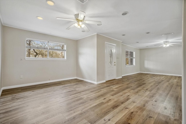 empty room with ceiling fan, ornamental molding, and light hardwood / wood-style floors