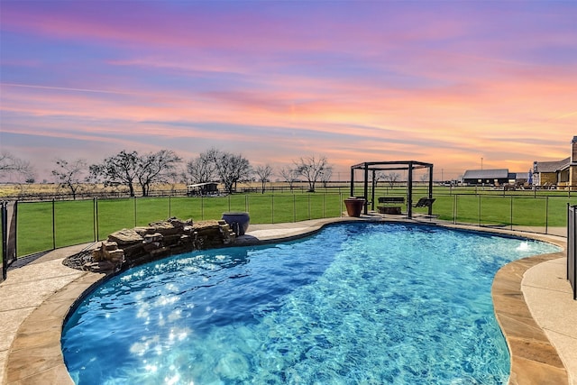 pool at dusk featuring a lawn