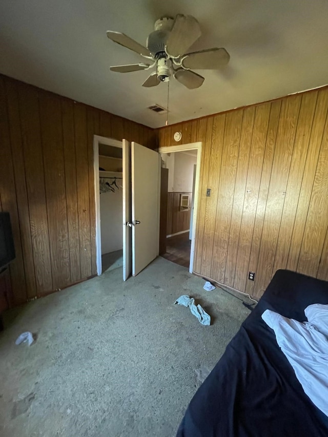 bedroom with wooden walls, a closet, and ceiling fan