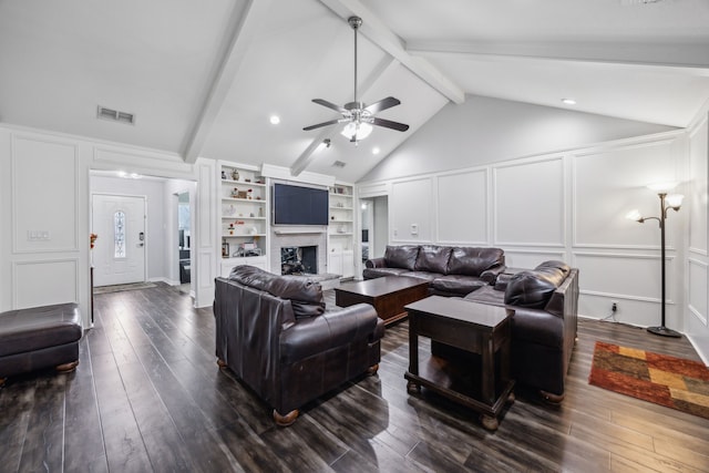 living room with vaulted ceiling with beams, dark wood-type flooring, ceiling fan, and built in shelves