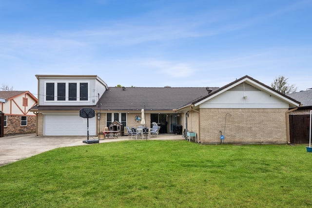 back of house featuring a garage, a yard, and a patio area