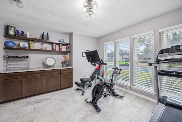 exercise room featuring a textured ceiling