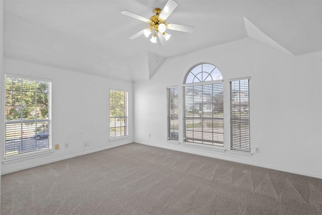 spare room featuring ceiling fan, light colored carpet, and vaulted ceiling