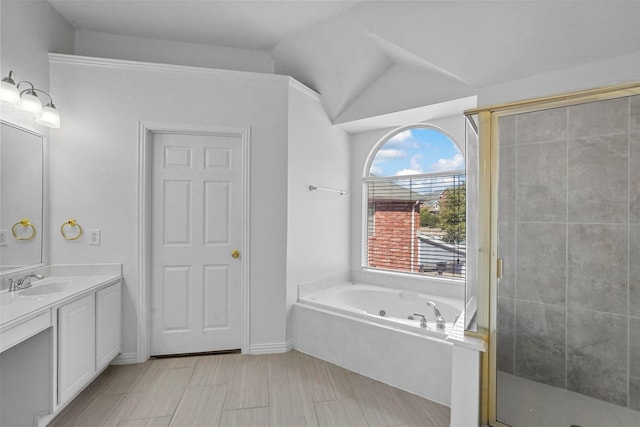 bathroom featuring vanity, vaulted ceiling, and shower with separate bathtub