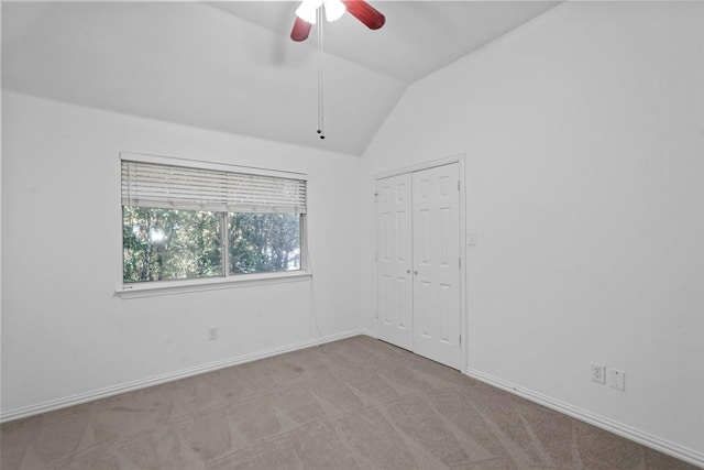 carpeted spare room featuring ceiling fan and lofted ceiling