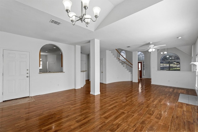 unfurnished living room featuring vaulted ceiling, dark hardwood / wood-style floors, and ceiling fan with notable chandelier