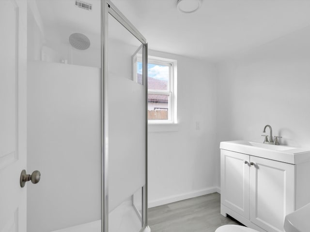 bathroom featuring a shower with door, vanity, and hardwood / wood-style flooring