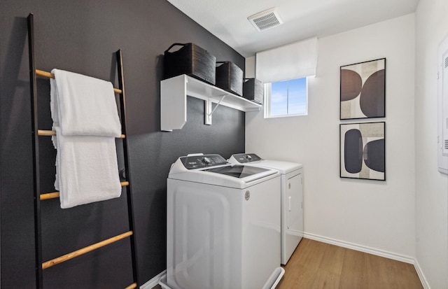 laundry area featuring light hardwood / wood-style floors and washing machine and clothes dryer