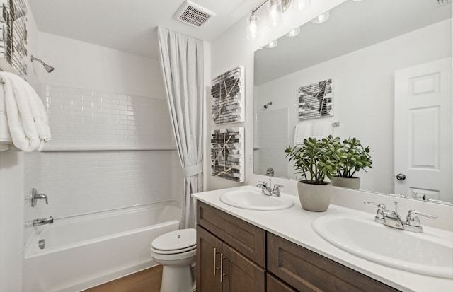 full bathroom featuring hardwood / wood-style flooring, vanity, shower / bathtub combination with curtain, and toilet