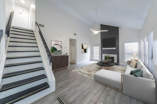 living room with high vaulted ceiling and a large fireplace