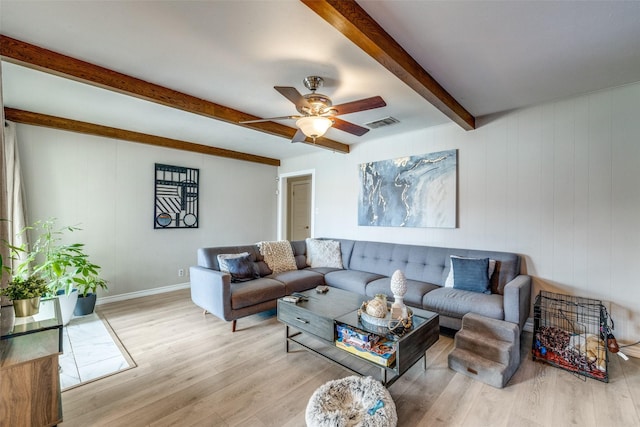 living room featuring ceiling fan, light hardwood / wood-style floors, and beamed ceiling