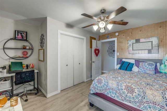 bedroom featuring light hardwood / wood-style floors, ceiling fan, and a closet