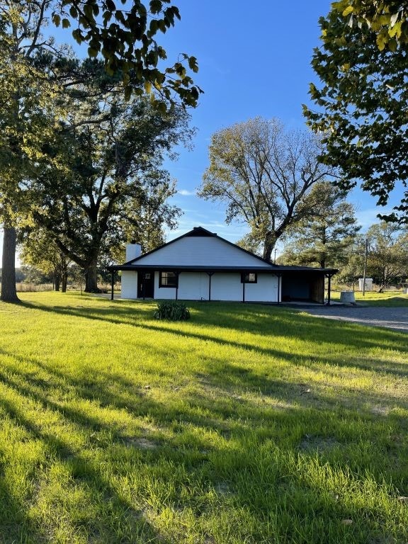 view of side of home with a yard