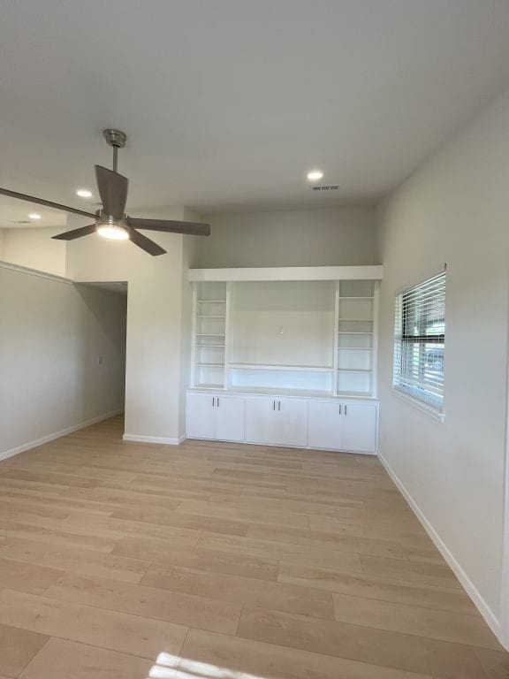 interior space with light wood-type flooring, ceiling fan, and a closet