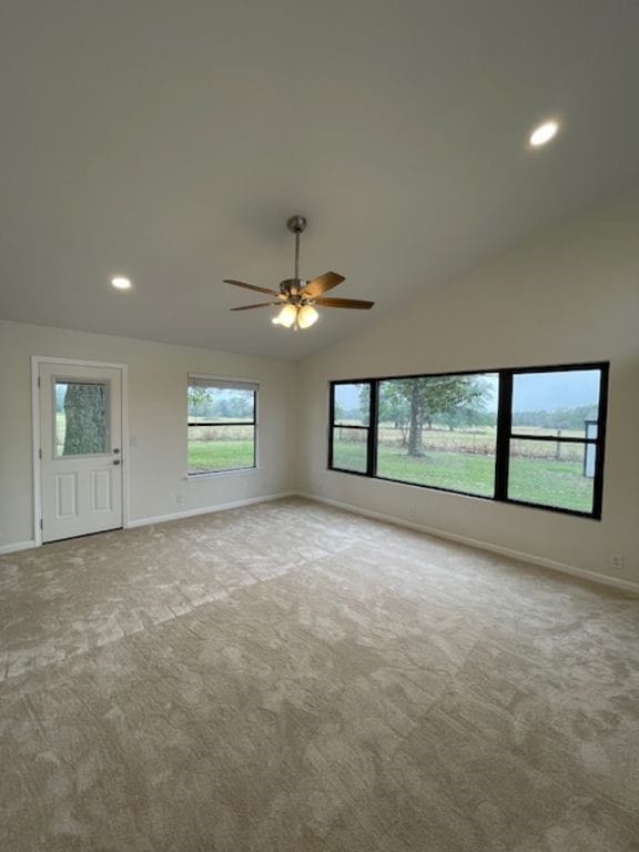 unfurnished living room with light carpet, vaulted ceiling, and ceiling fan