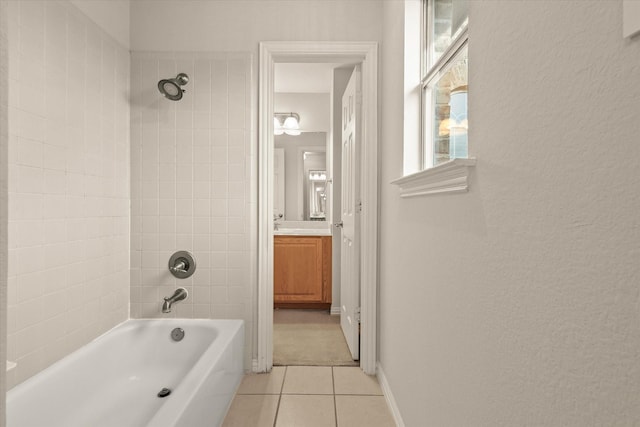 bathroom with vanity, tiled shower / bath combo, and tile patterned flooring