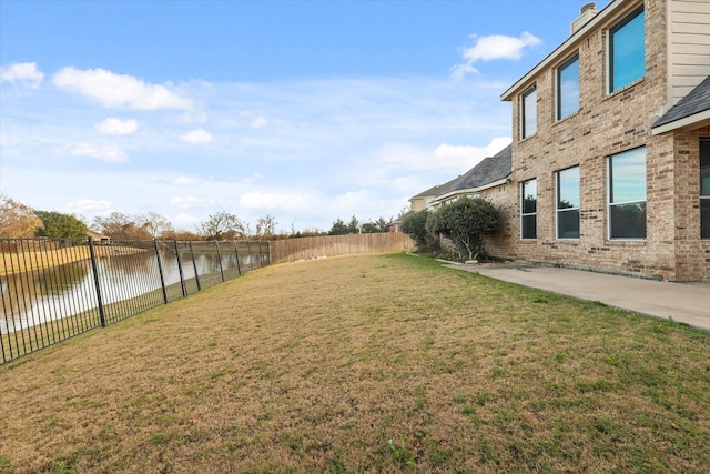 view of yard with a water view and a patio