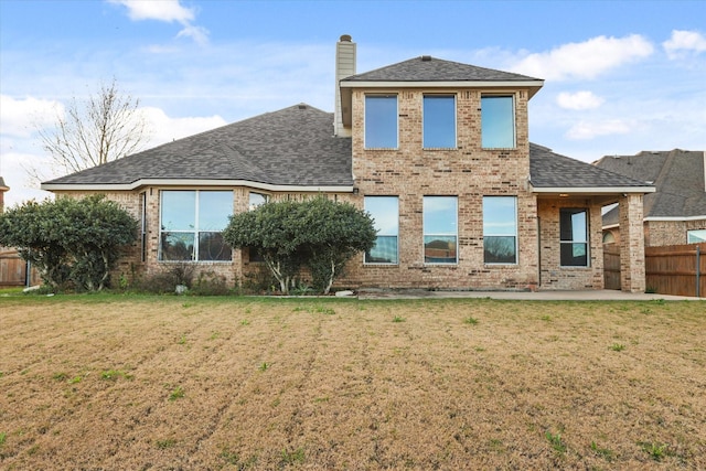 rear view of property featuring a yard and a patio area