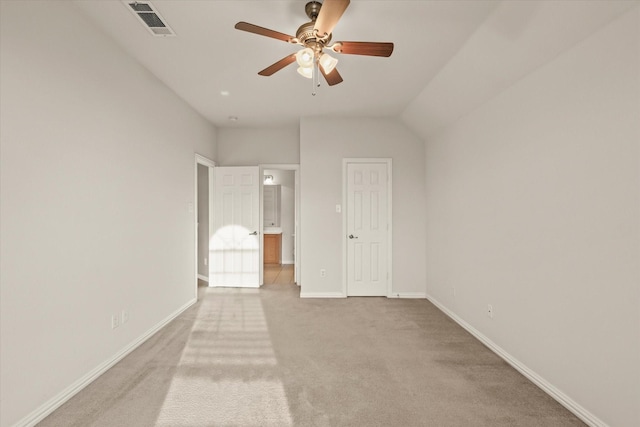 unfurnished bedroom with light carpet, lofted ceiling, a closet, and ceiling fan