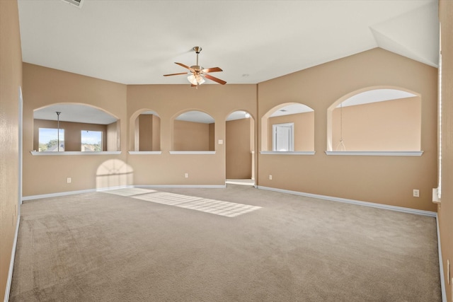 empty room featuring ceiling fan, lofted ceiling, and carpet flooring