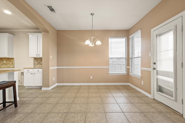 unfurnished dining area with a notable chandelier and light tile patterned floors