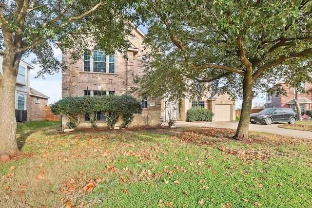 view of front facade featuring a garage, central AC unit, and a front yard