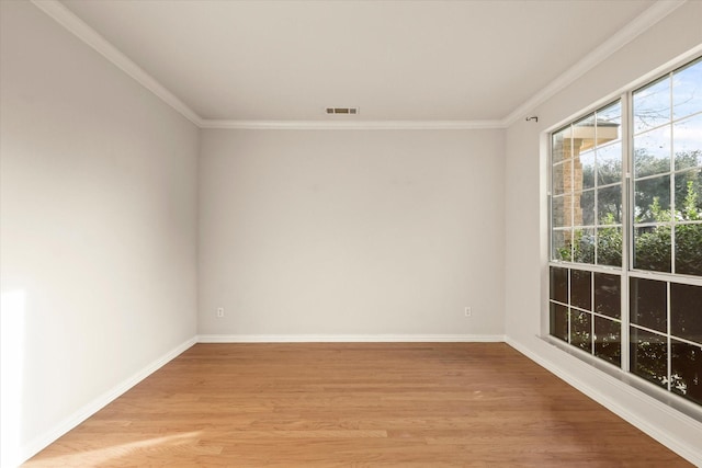 spare room featuring crown molding and light hardwood / wood-style floors