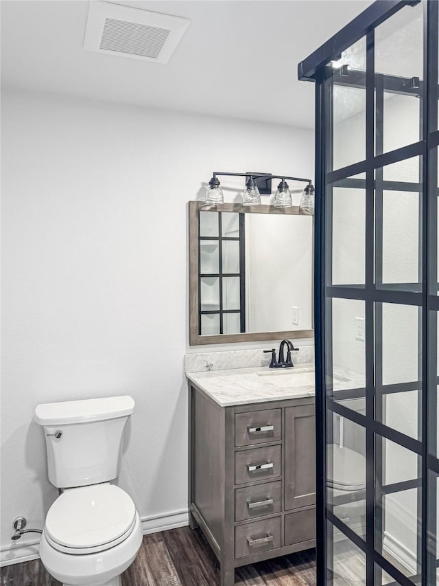 bathroom with vanity, wood-type flooring, and toilet