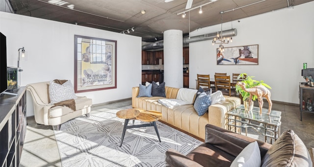 living room featuring rail lighting and a chandelier